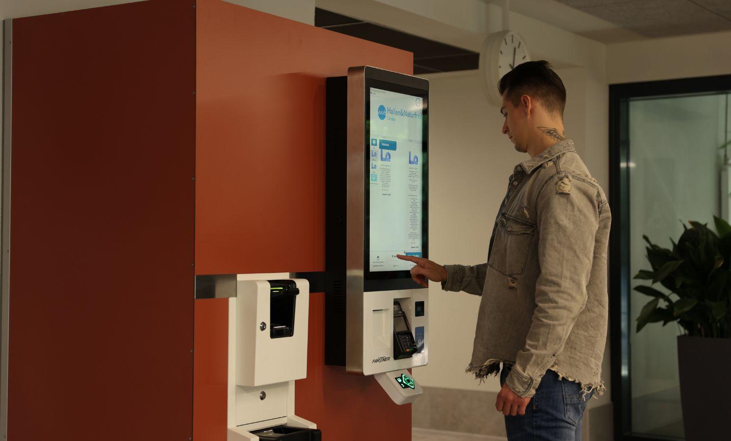 someone booking a ticket with a self-service kiosk