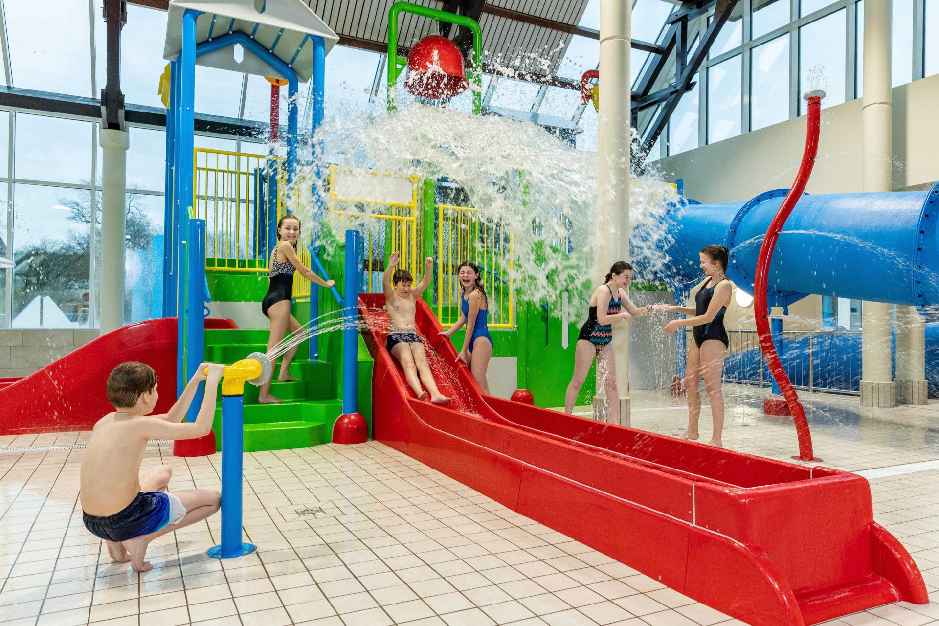 Kids having fun at a water park, enjoying various slides and water features