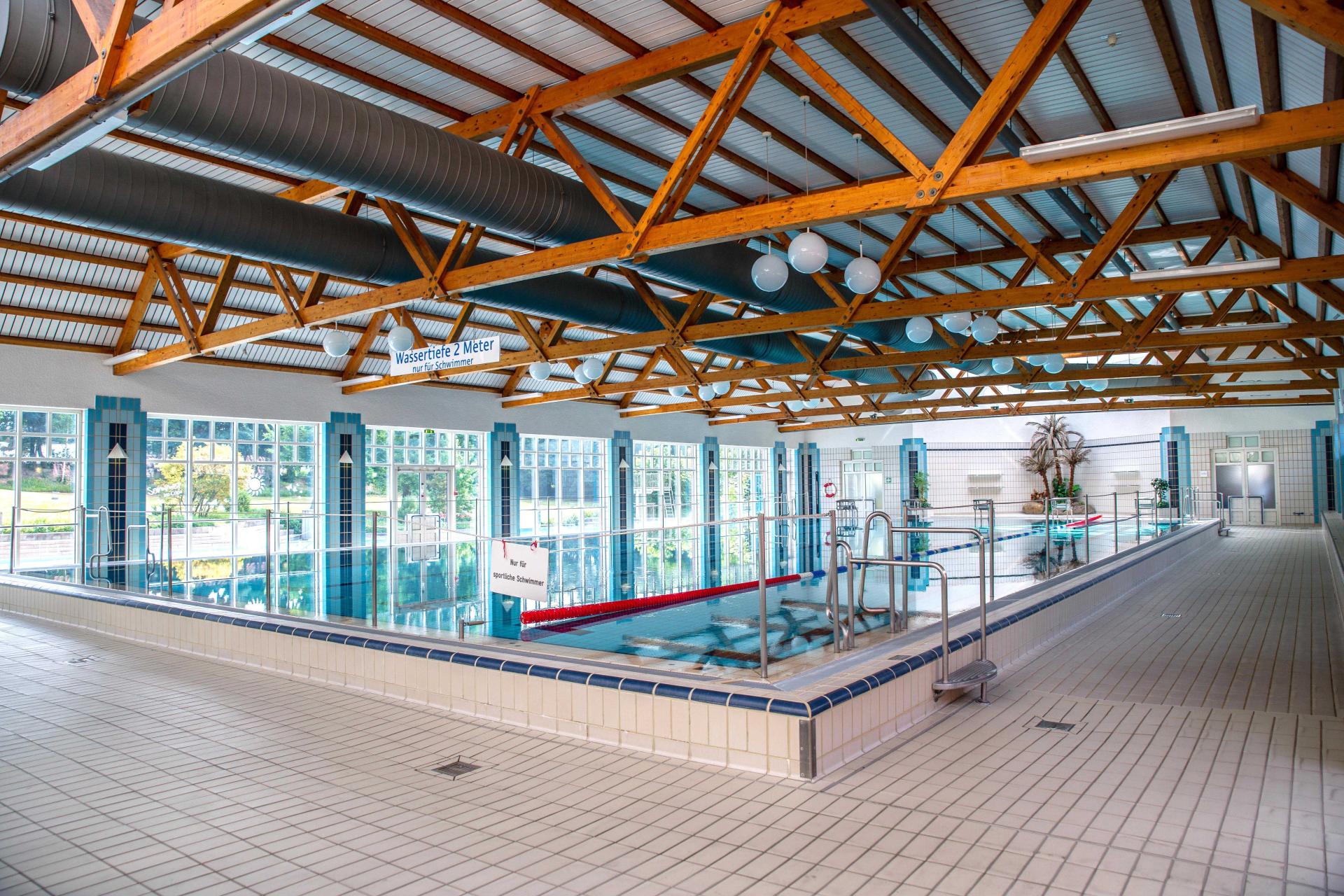 A large indoor swimming pool with bright lighting, designed for competitive swimming in a sports environment.